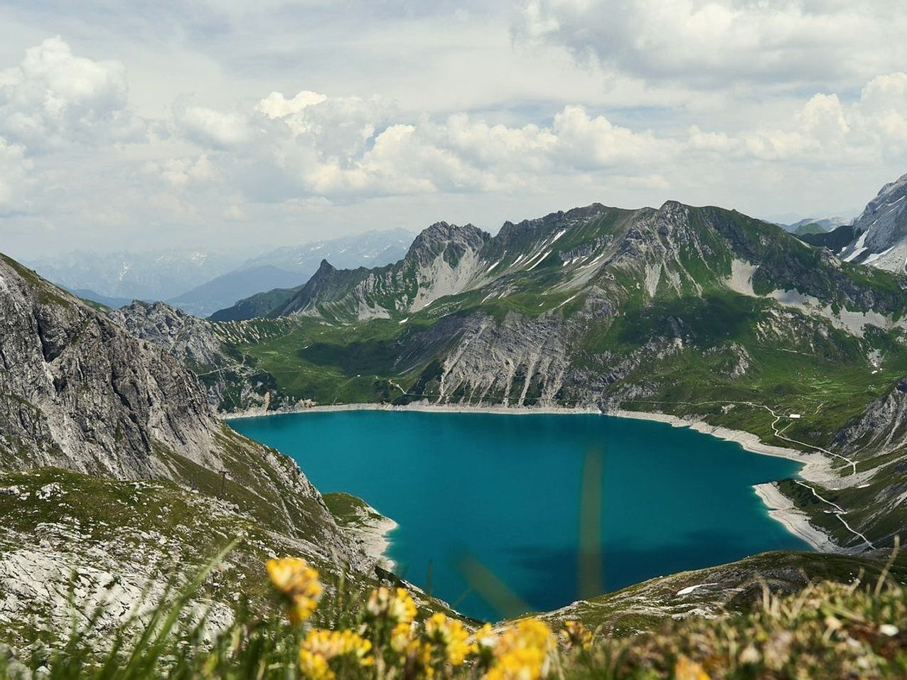 Uma mochila esvaziada e organizada sobre uma pedra plana à beira do lago