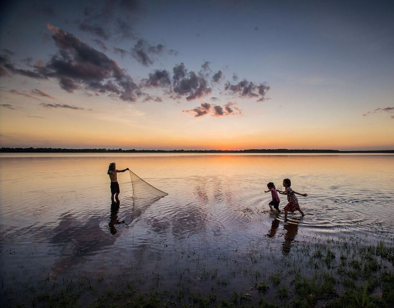 Uma bancada com mapas de lagos, fotografias de peixes e cadernos de anotações abertos